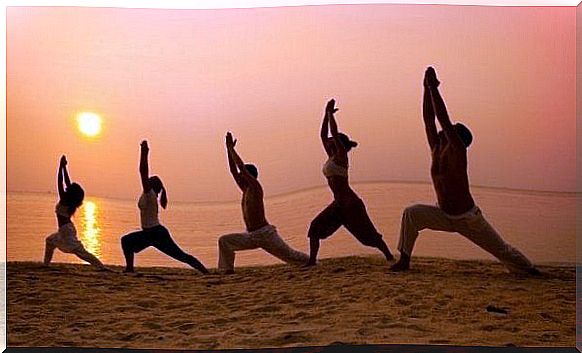 People practice tai chi on the beach