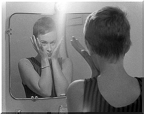 Woman looks at herself in the mirror