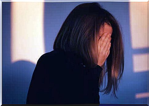 Woman hiding face behind hands feels guilt