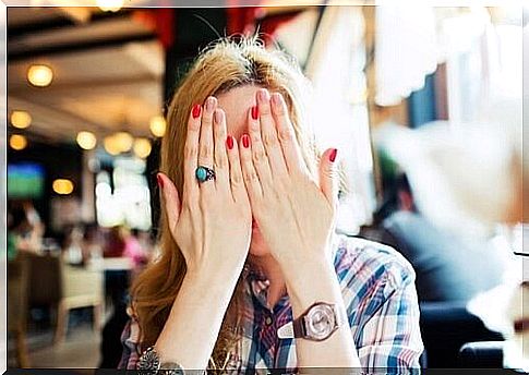 Woman hides her face with her hands 