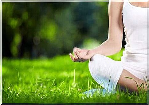 Woman meditating on a lawn