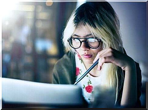 Woman at computer struggling to work and study at the same time