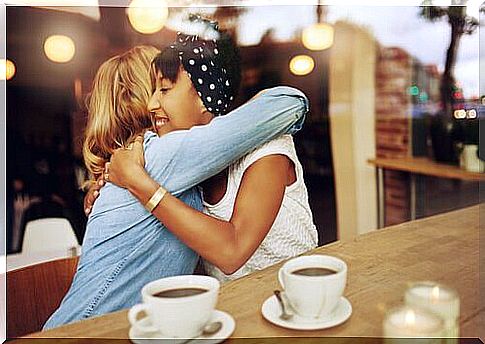 Healthy friendships are illustrated by girlfriends hugging at the café