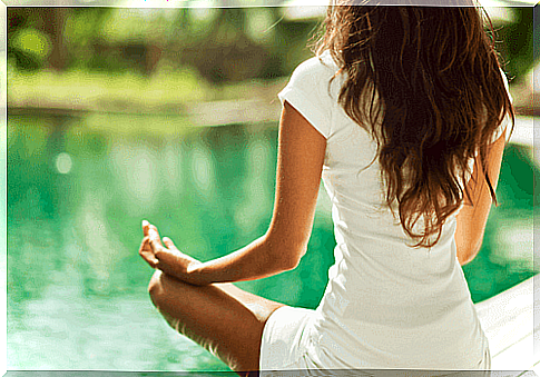 woman meditating by water