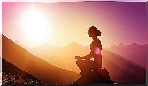 Woman meditating on mountain top