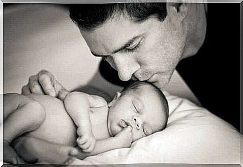 father kissing baby on the head