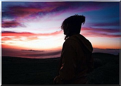 Woman looking at a beautiful and colorful evening sky