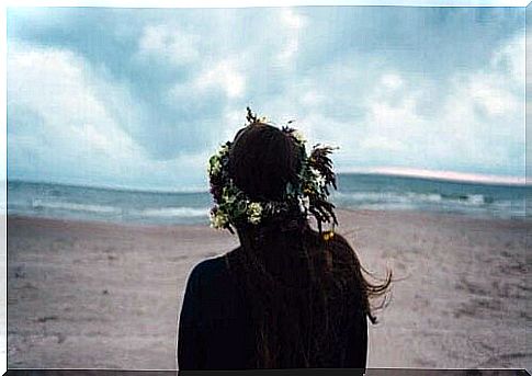 Woman with flower wreath in her hair by the beach