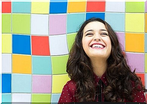 Woman smiling in front of a colorful background