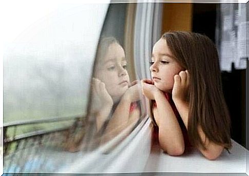 Girl looks out of window as symbol of children's fear