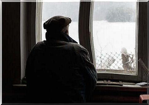 Elderly man looking out the window