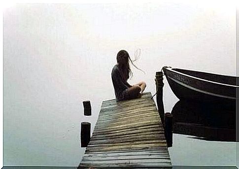 Woman sitting alone on bridge