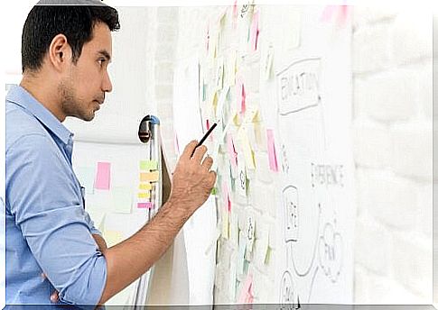 A man looks at notes on a whiteboard