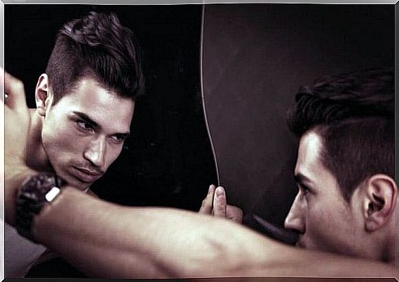 Man looks intensely at his mirror image