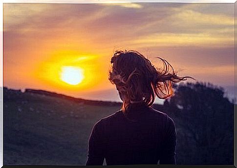 Woman enjoys sunset and chooses to live in the now