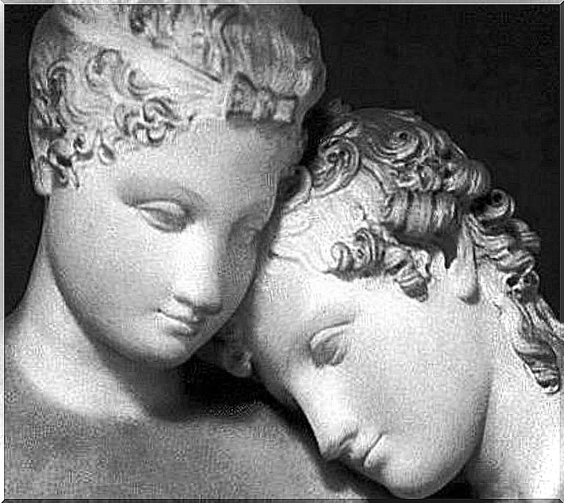 Two statues with their heads close together