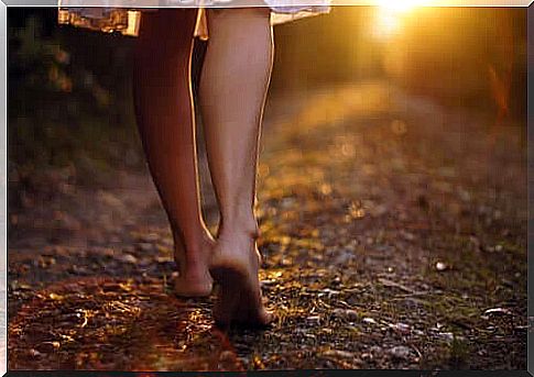 woman walking barefoot in forest