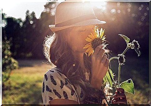 Woman smells of sunflower and reflects the importance of unwinding yourself