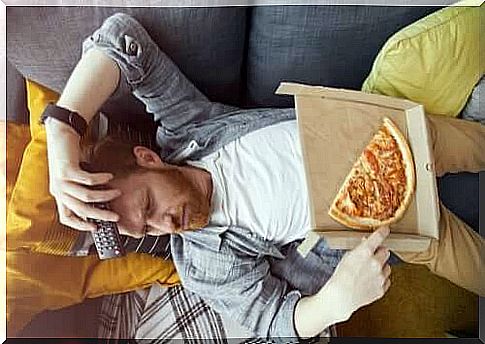 Man lying on sofa with pizza