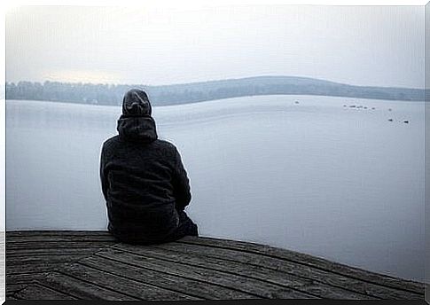 A man is sitting by the sea thinking 