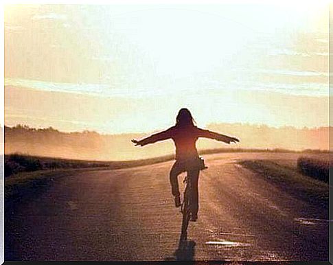 woman cycling without hands on handlebars