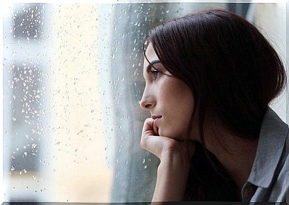 woman with depression looking out the window