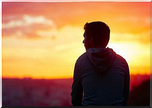 man sitting and enjoying the sunset