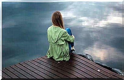 woman sitting by a jetty